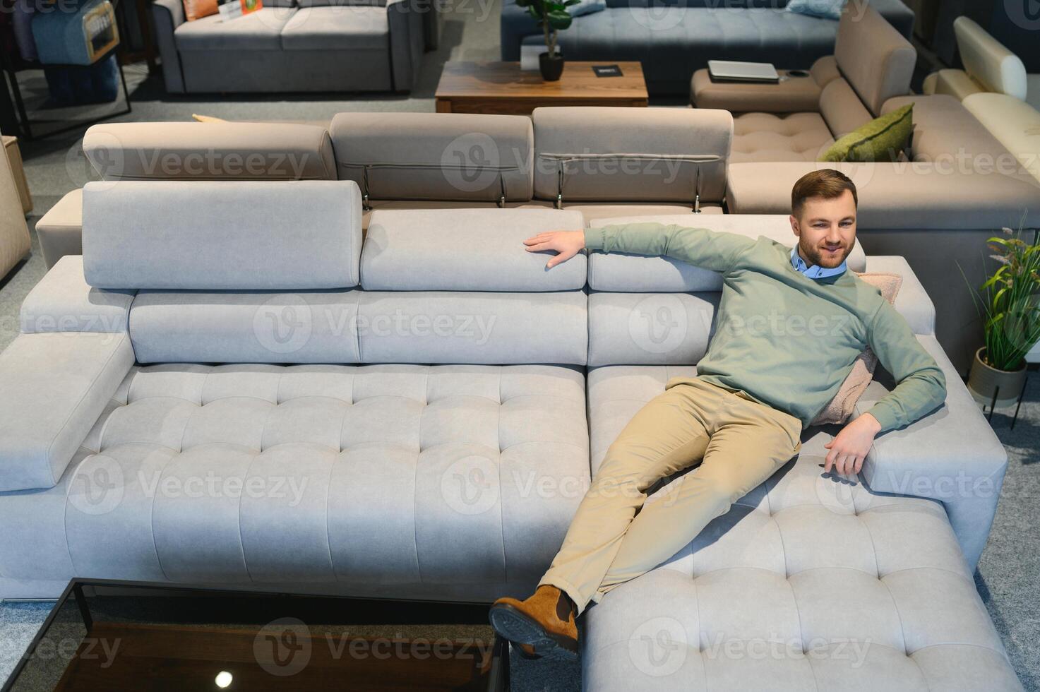 un hermoso joven hombre elige mueble en un Tienda foto