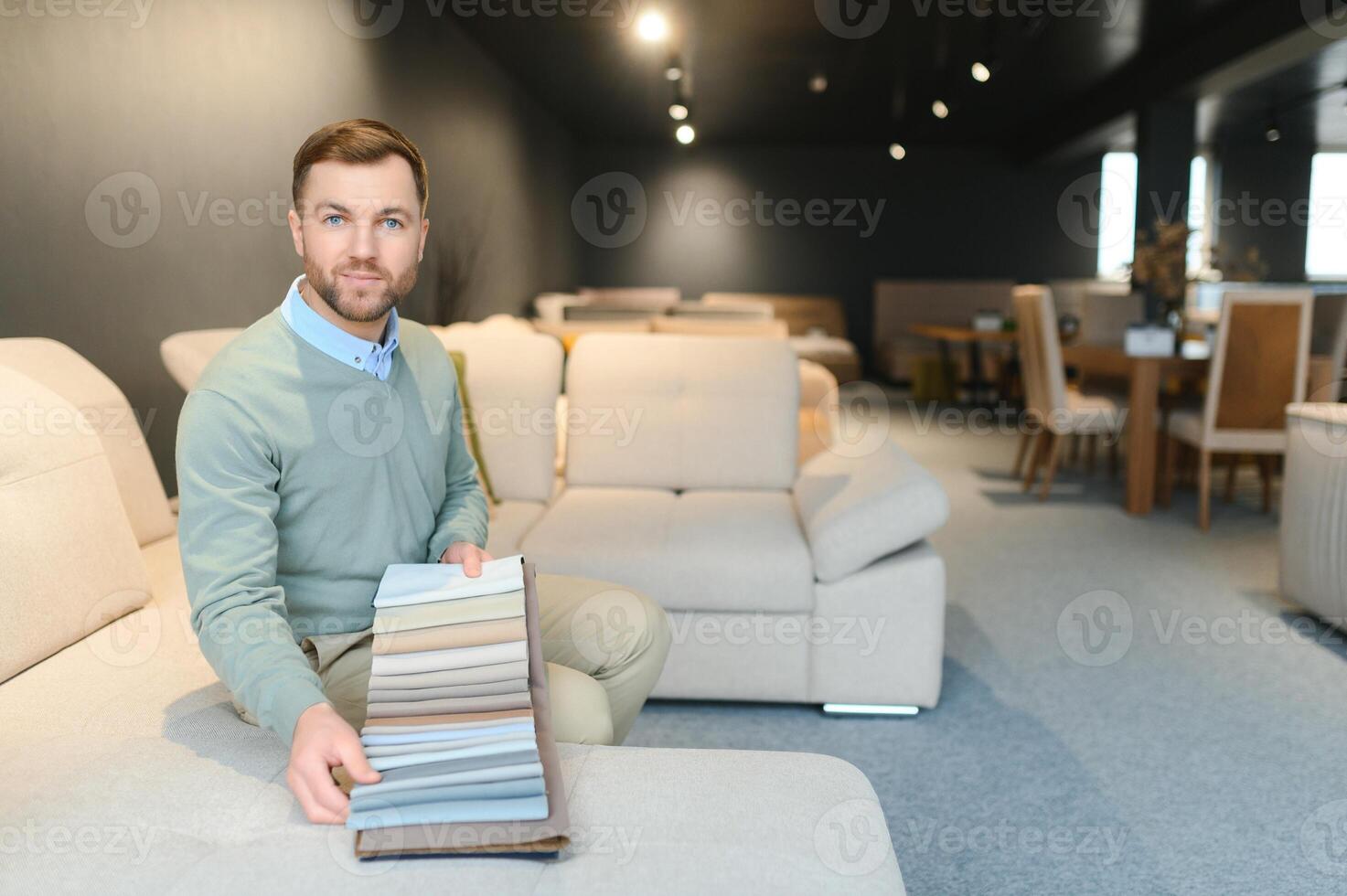 Man in furniture store choosing sofa photo