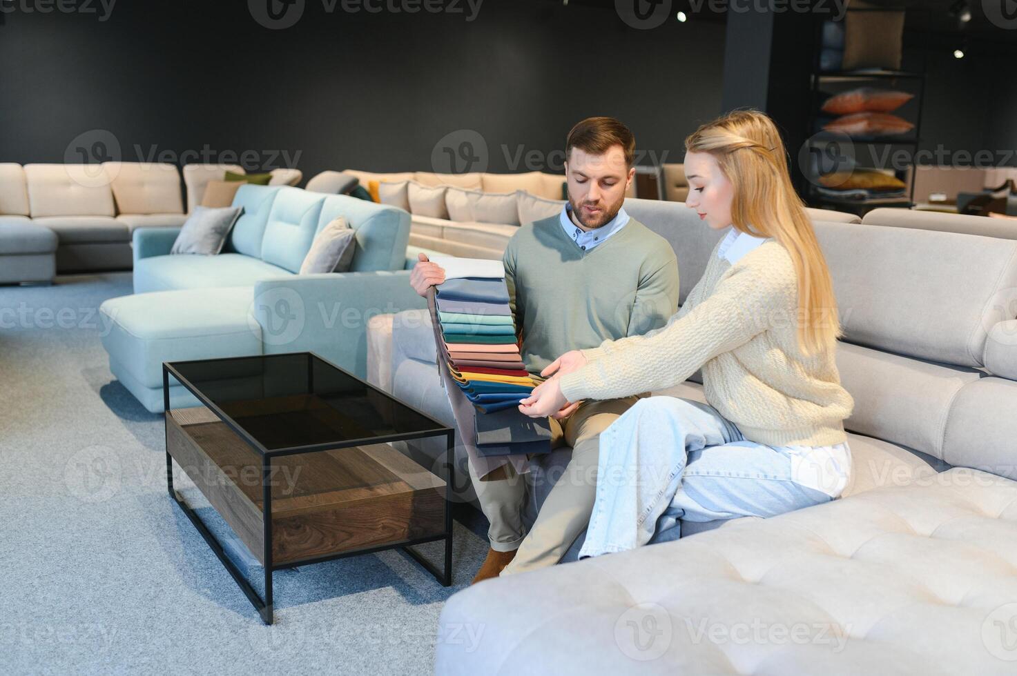 Woman and man looking at textile swatch in furniture store photo