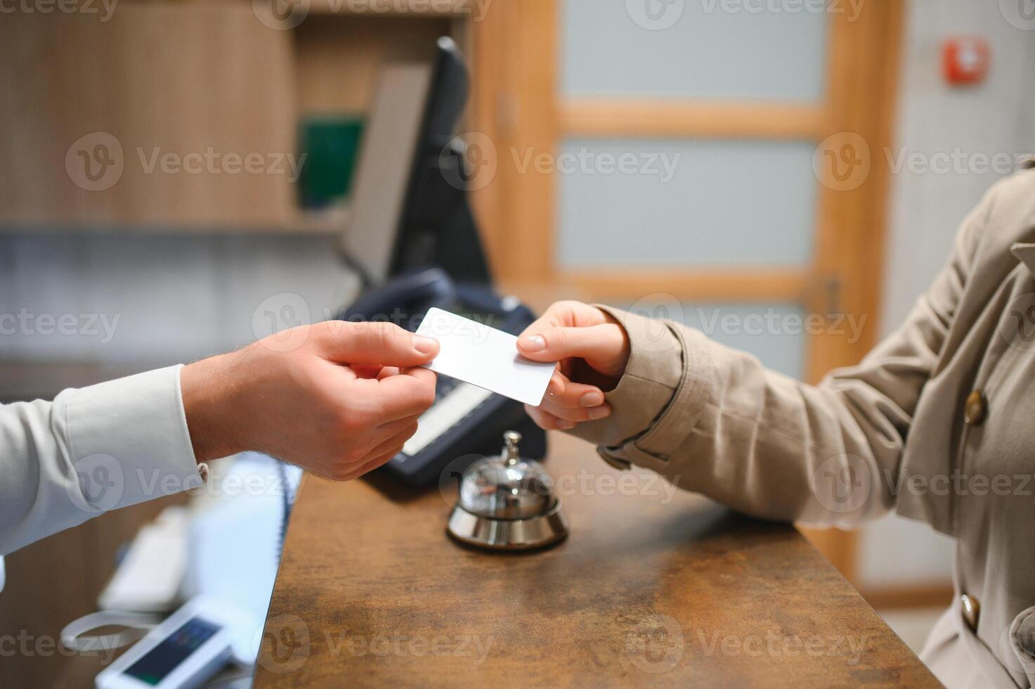 Close up of hand guest takes room key at check-in desk of the hotel. Hotel concept photo