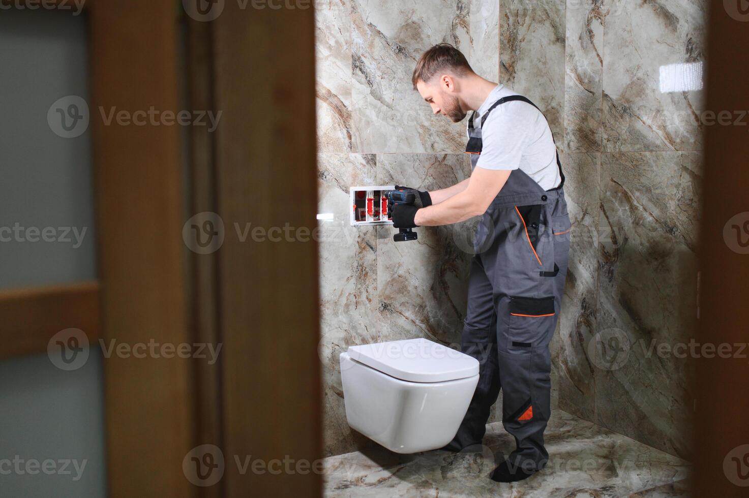 Plumber installing toilet in restroom photo