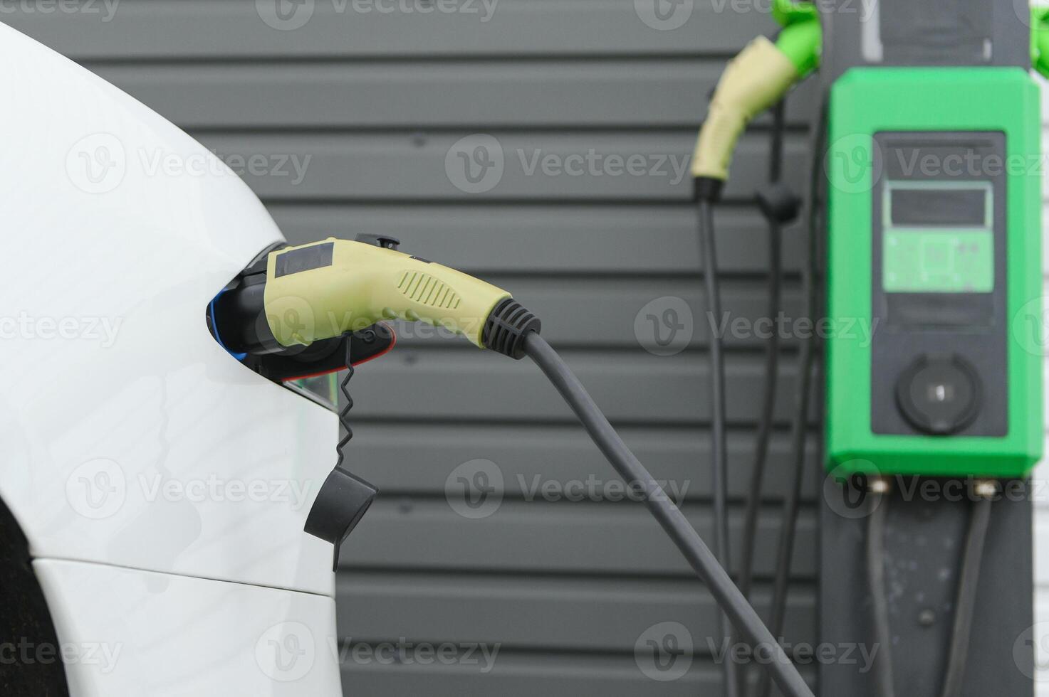 Power supply for electric car charging. Electric car charging station. Close up of the power supply plugged into an electric car being charged photo