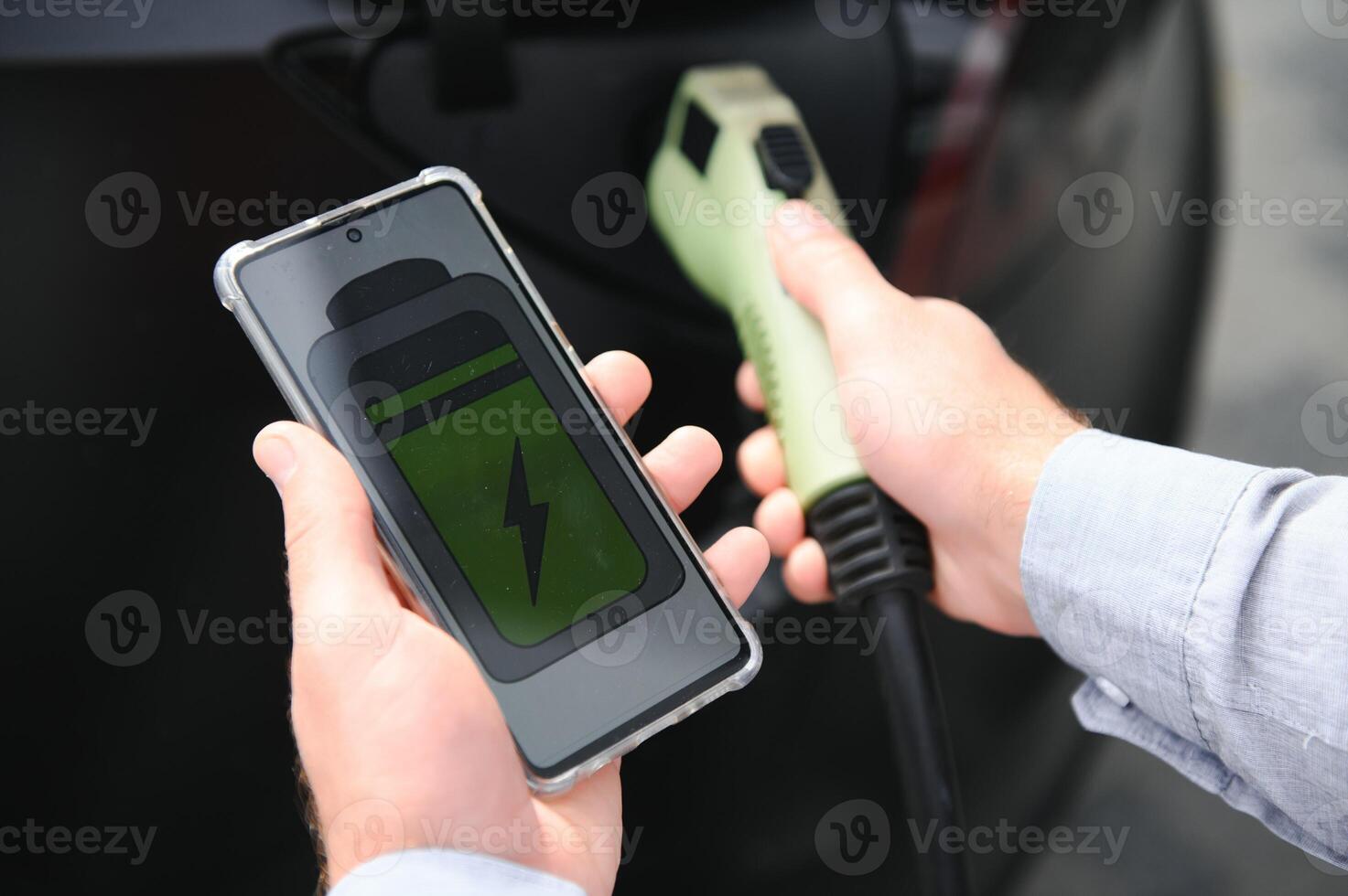 a man charges an electric car photo