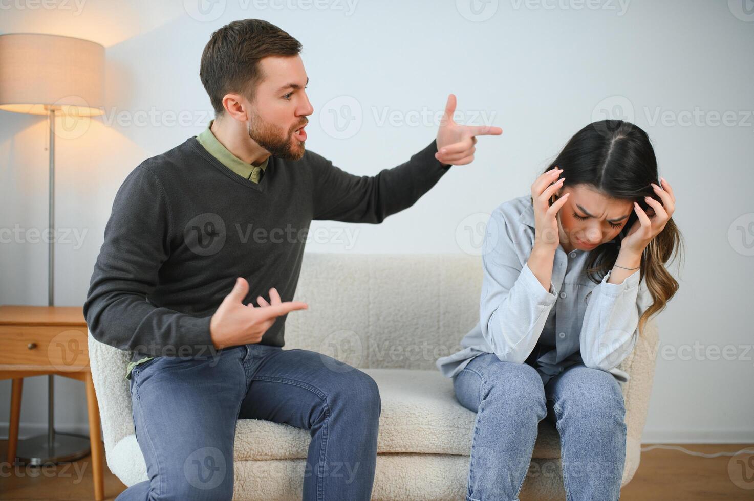 irritado marido es gritos a su esposa con violencia. mujer es cubierta su cara con temor foto