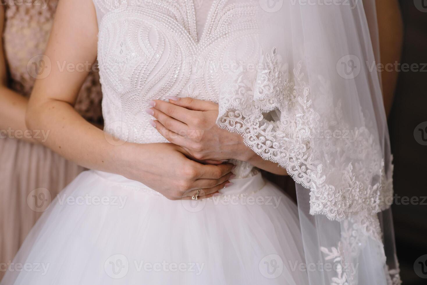 Bridesmaid preparing bride. Bridesmaid helps fasten a wedding dress the bride before the ceremony. Luxury bridal dress close up. Best wedding morning photo