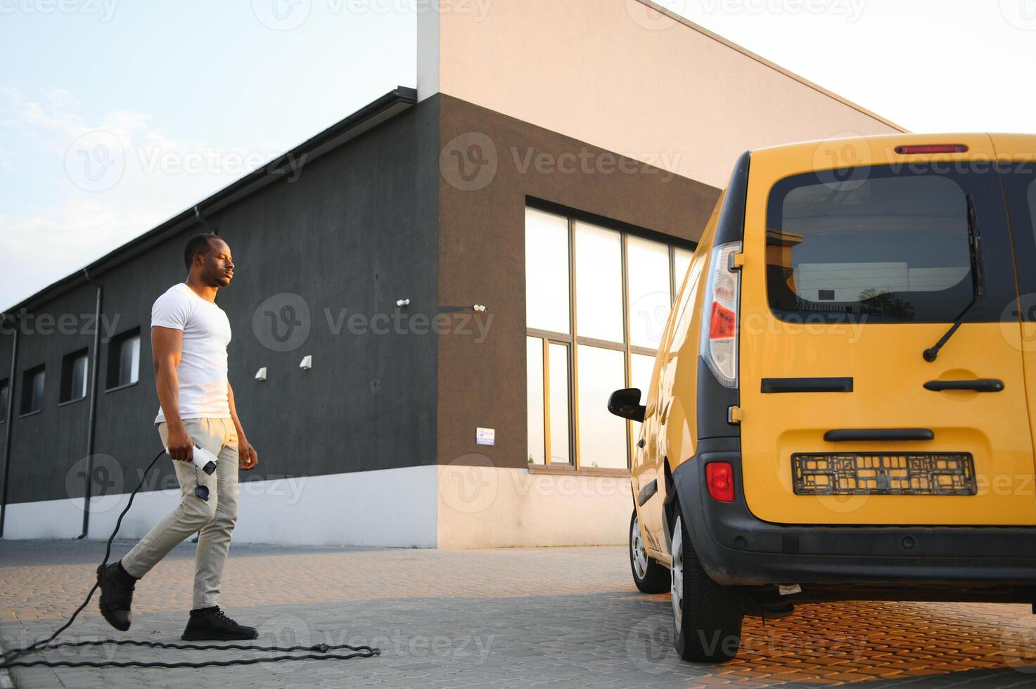 African American man charging his electric car. photo