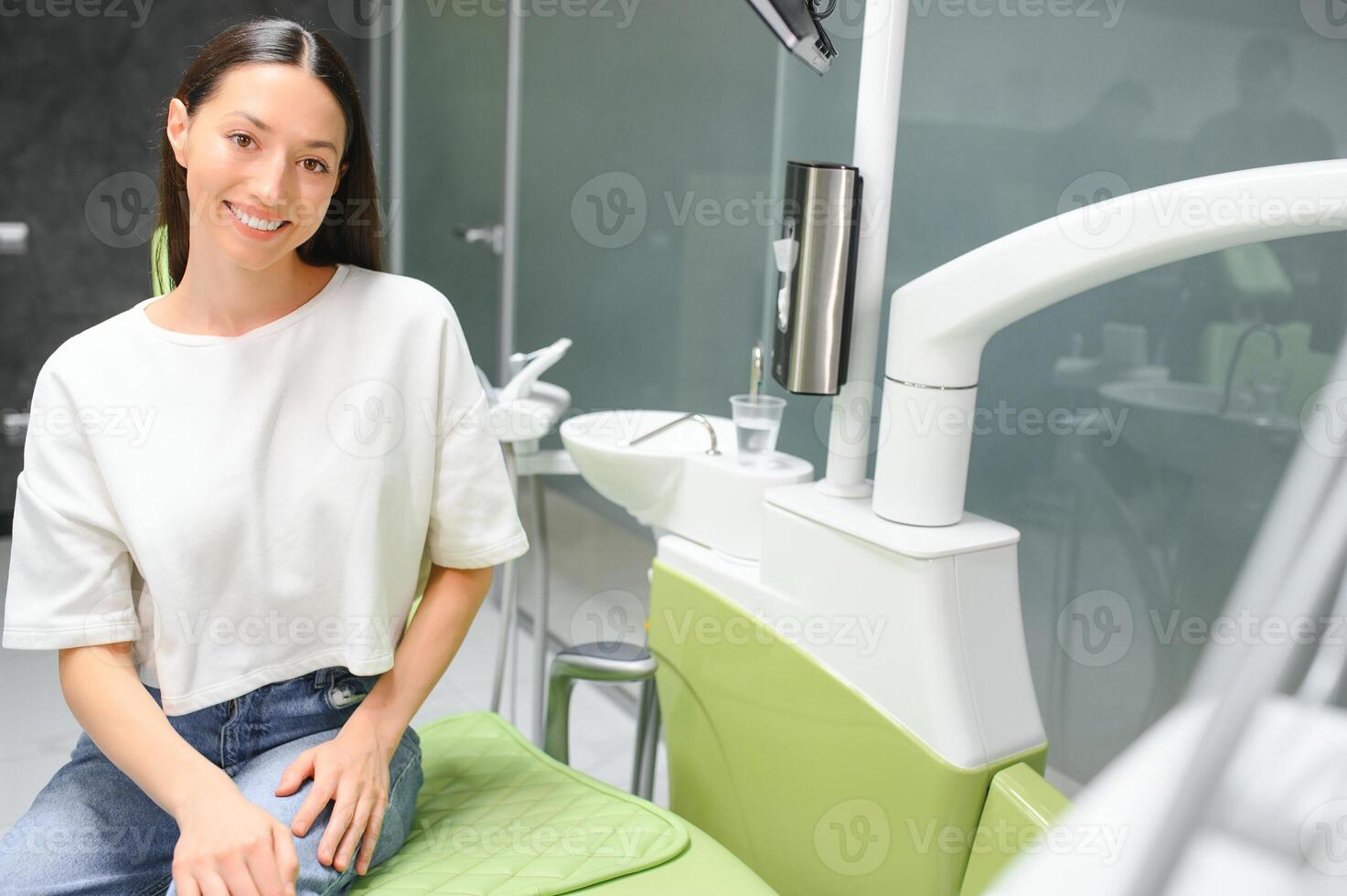 Patient with perfect white teeth and smile satisfied after dental treatment in a dentist photo