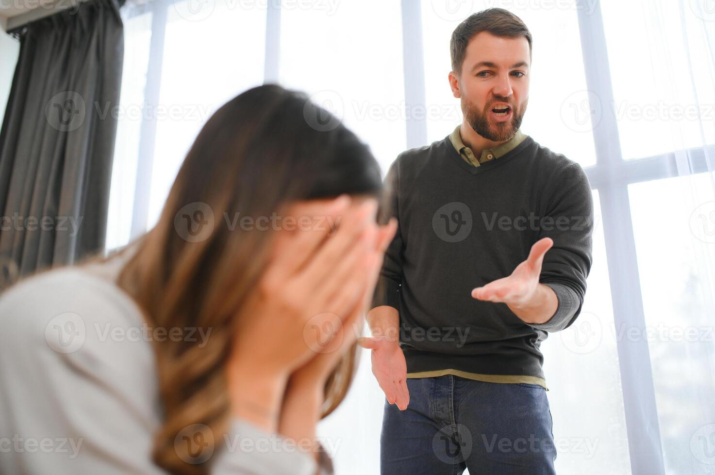 An agitated and upset husband shouts and looks at his wife, a quarrel between spouses. Family misunderstanding, quarrel photo