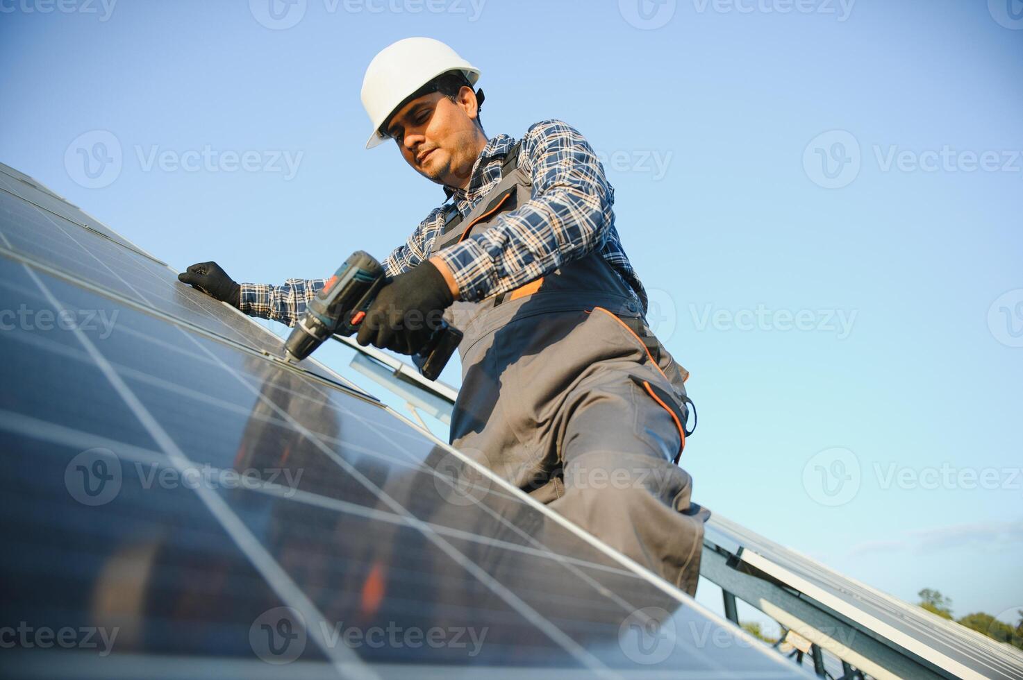 An Indian worker installs solar panels. The concept of renewable energy. photo