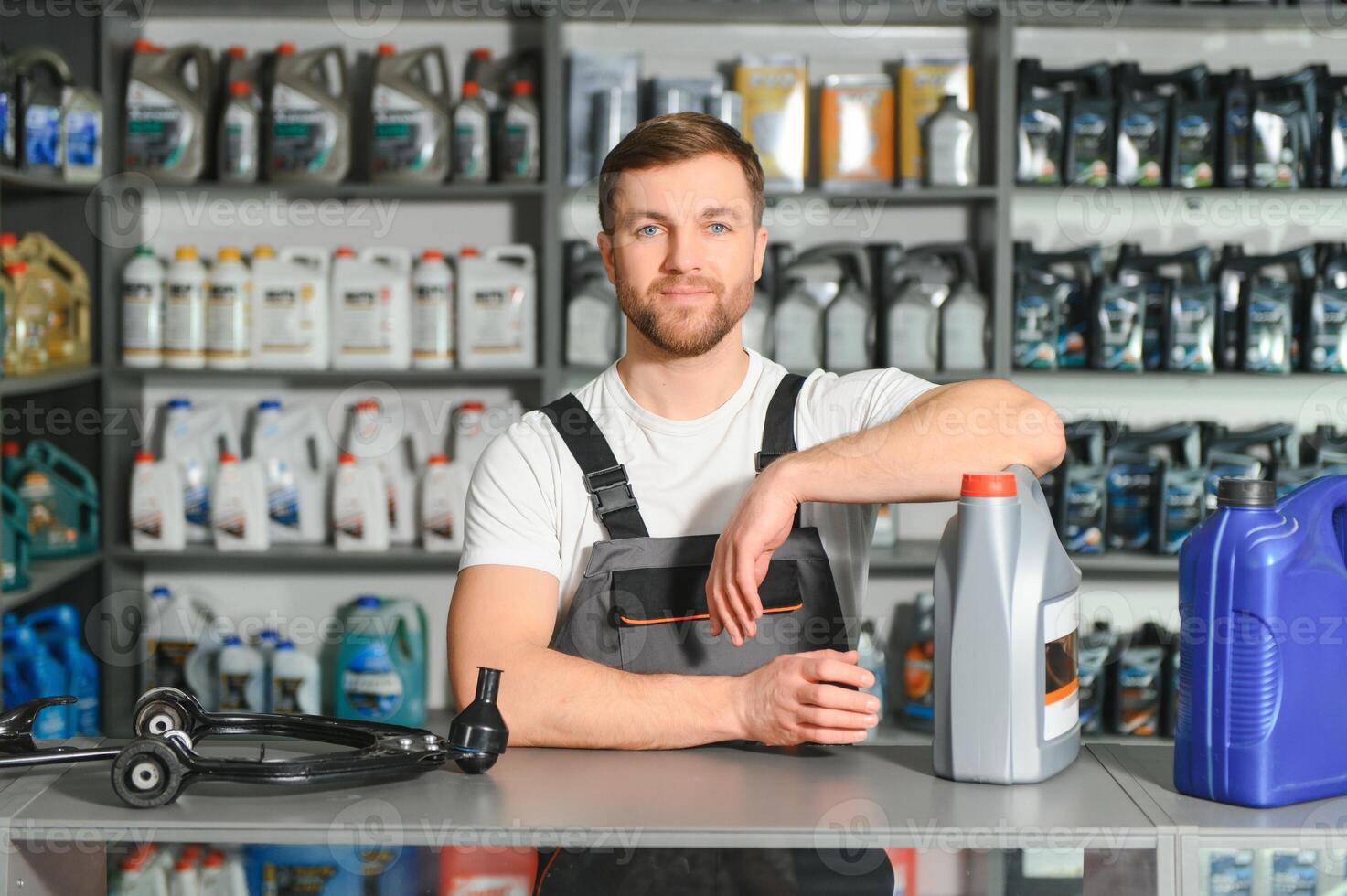 seller man with canister of motor oil in auto store photo