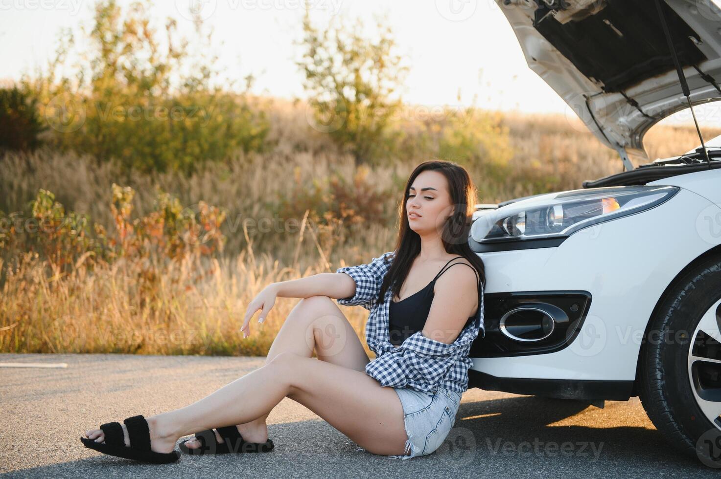 Sad woman depressed not knowing what to do with broken car photo