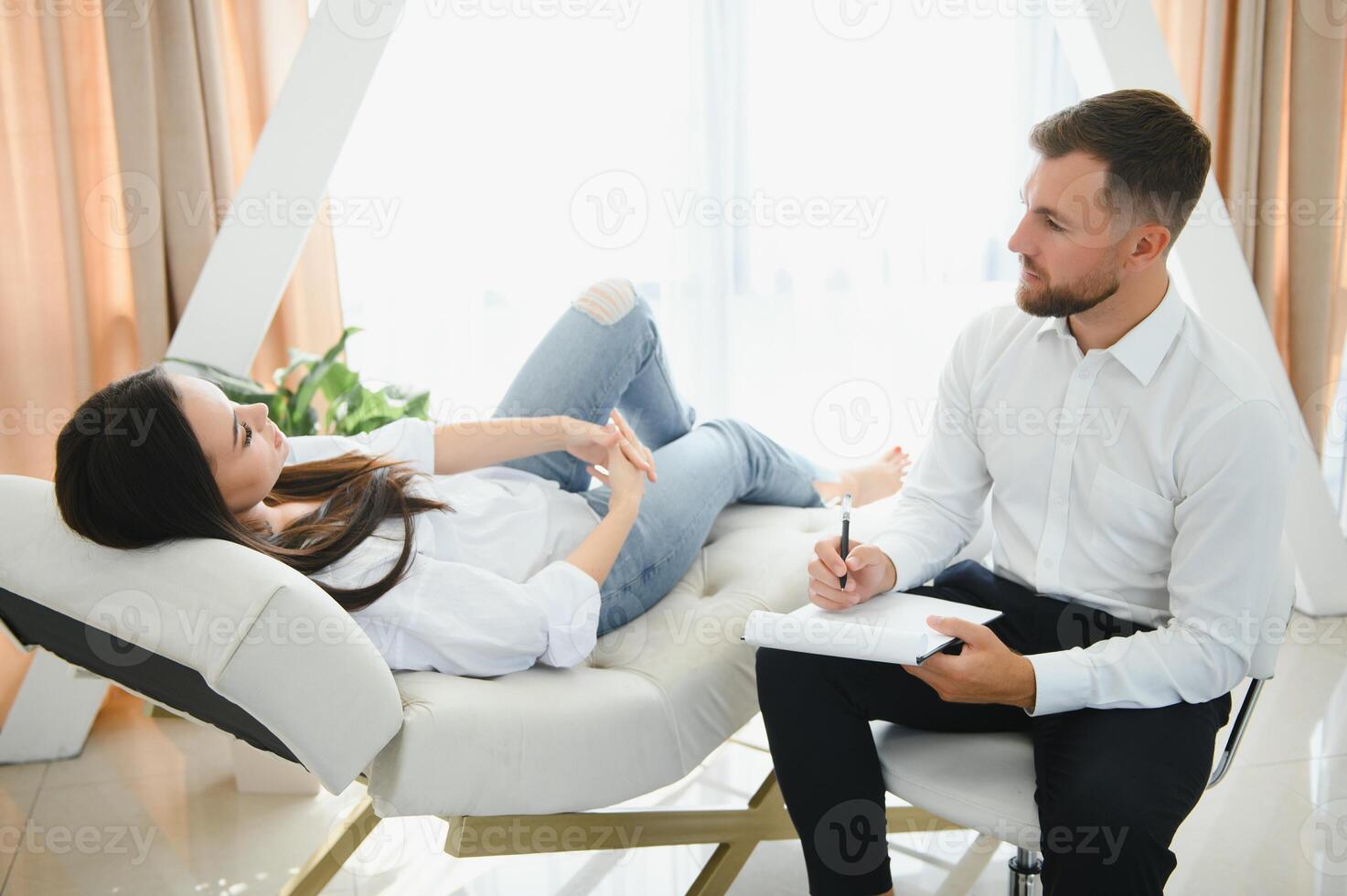 psicólogo tomando notas durante terapia sesión con triste joven mujer en su oficina. Copiar espacio foto