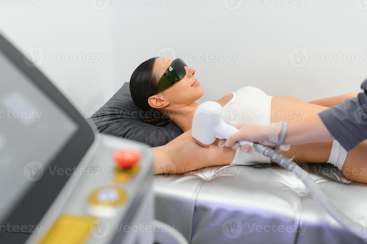 Laser cosmetology Armpit hair removal. Beautiful smiling woman client having procedure photo