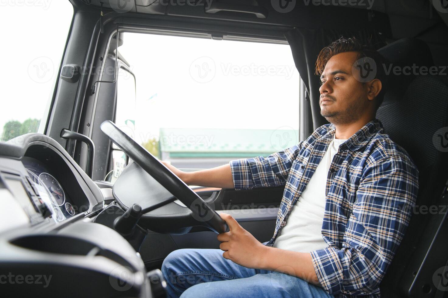 Portrait of a young handsome Indian truck driver. The concept of logistics and freight transportation. photo