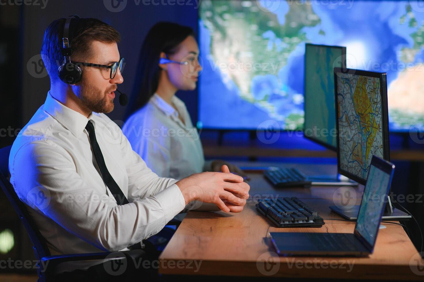 Male Data Scientist Works on Personal Computer Control and Monitoring Room. Map Surveillance of People Walking on City Streets photo