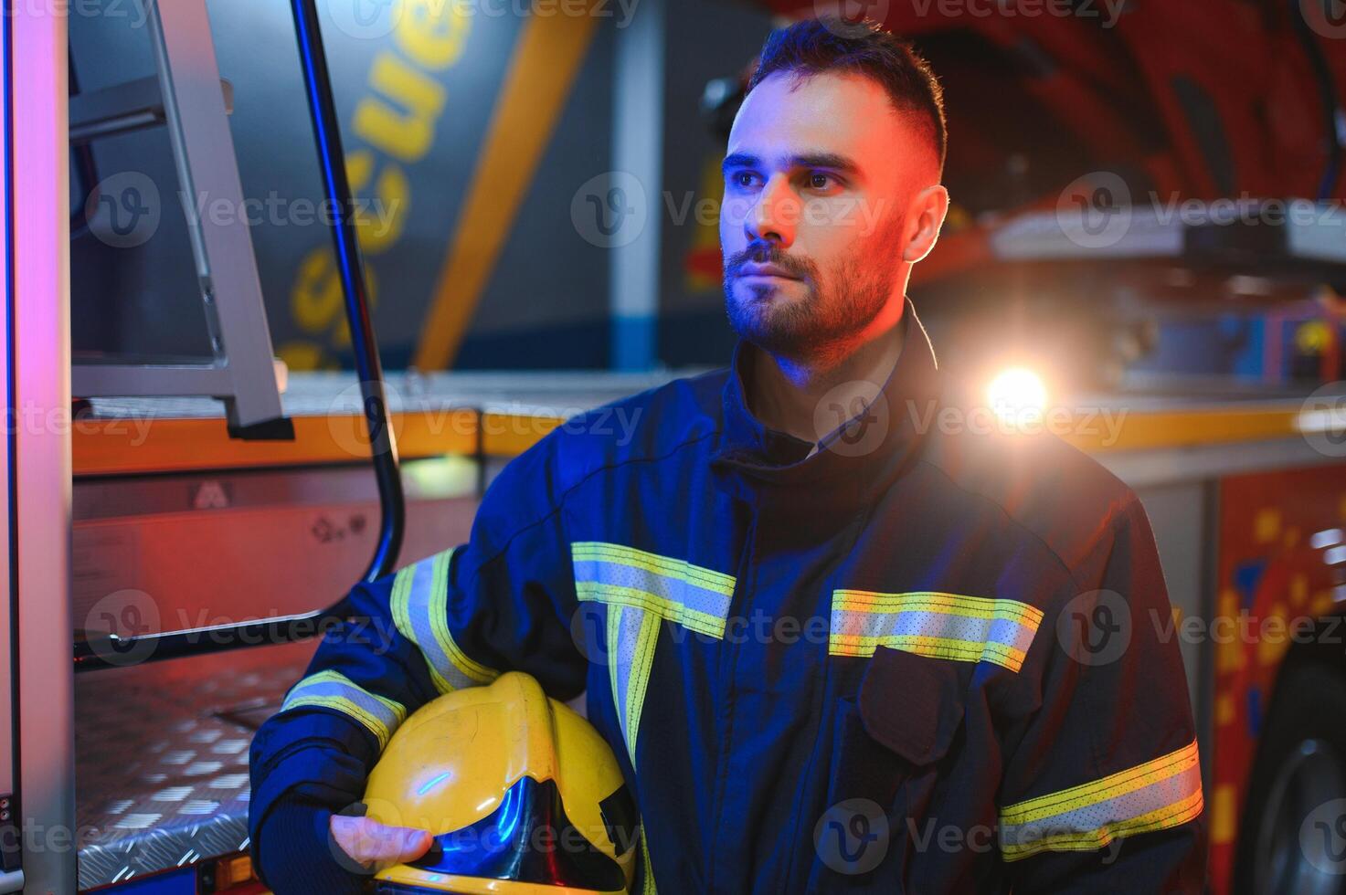 Firefighters man in a protective suit near fire truck. Protection, rescue from danger. Fire station photo