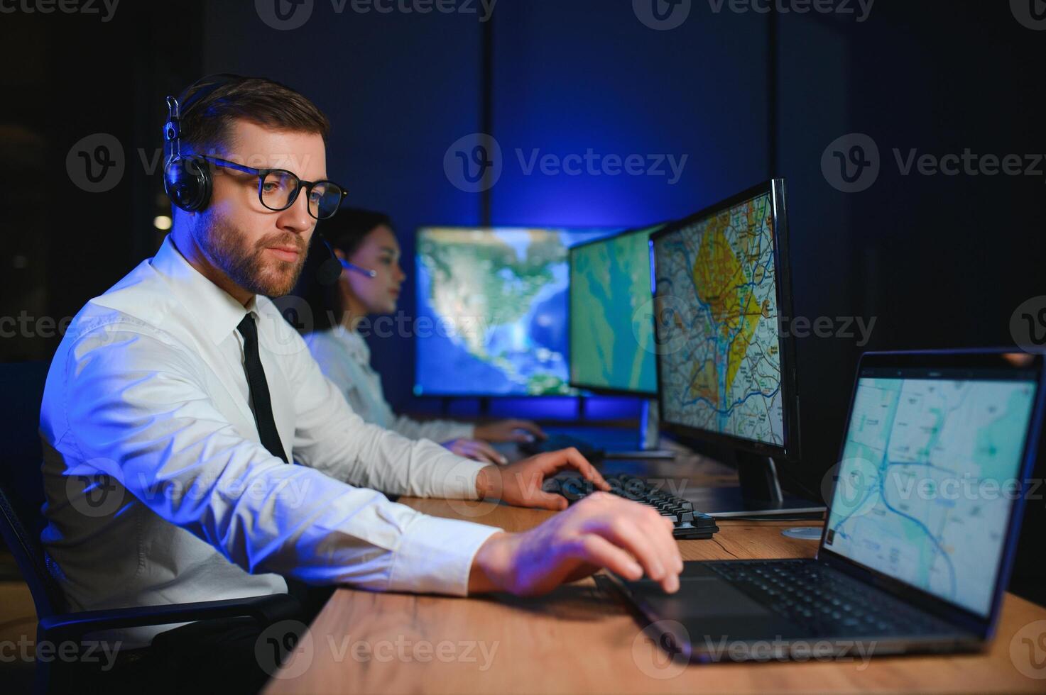 Male Data Scientist Works on Personal Computer Control and Monitoring Room. Map Surveillance of People Walking on City Streets photo