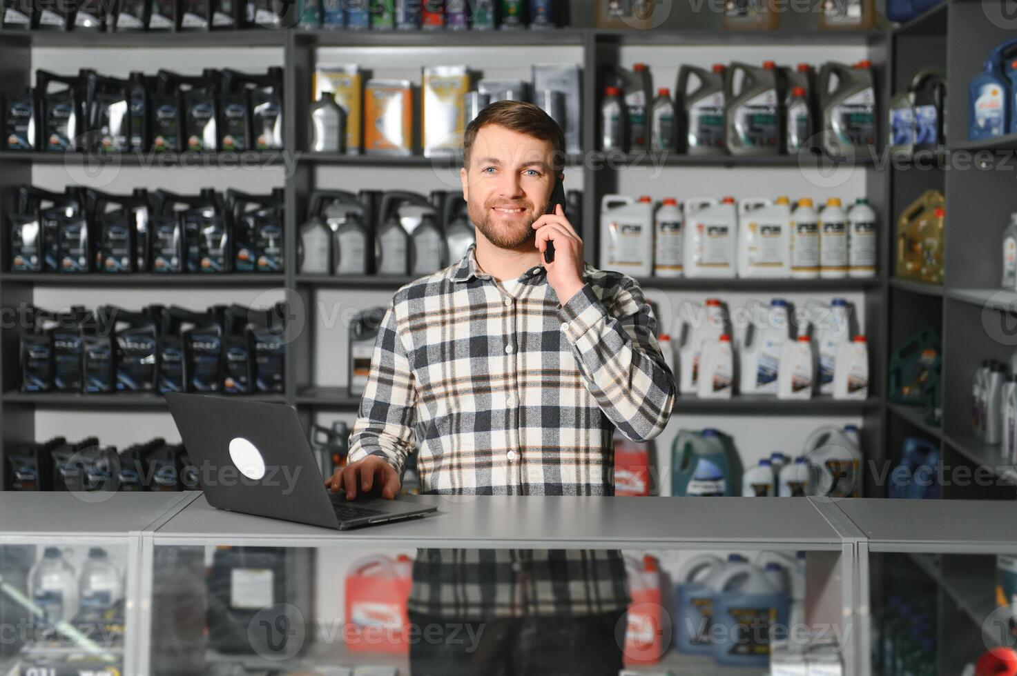 A salesman in an auto parts store is talking to a customer on the phone photo