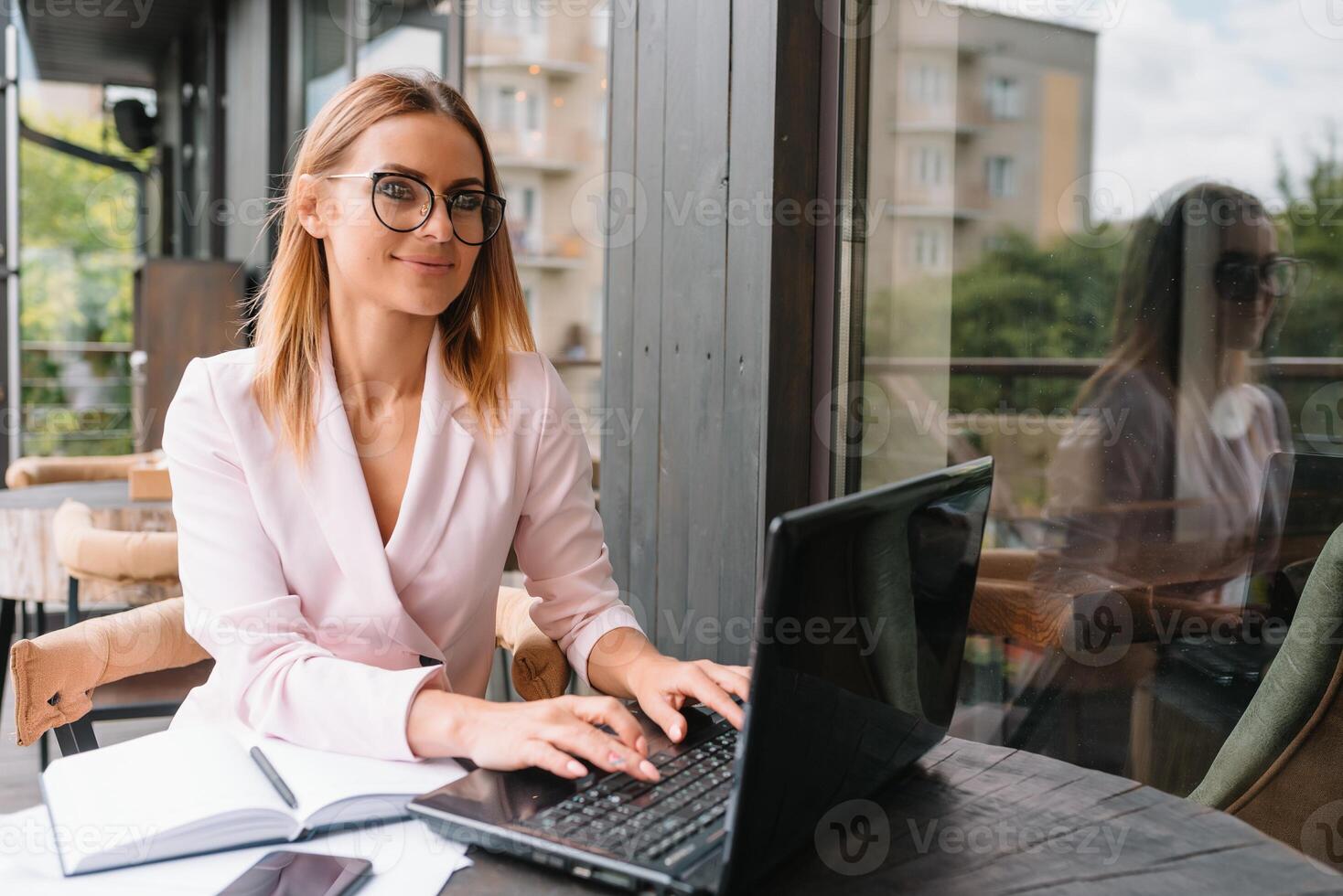 Portrait of young attractive businesswoman examining paperwork in bight light office interior sitting next to the window, business woman read some documents before meeting, filtered image. photo