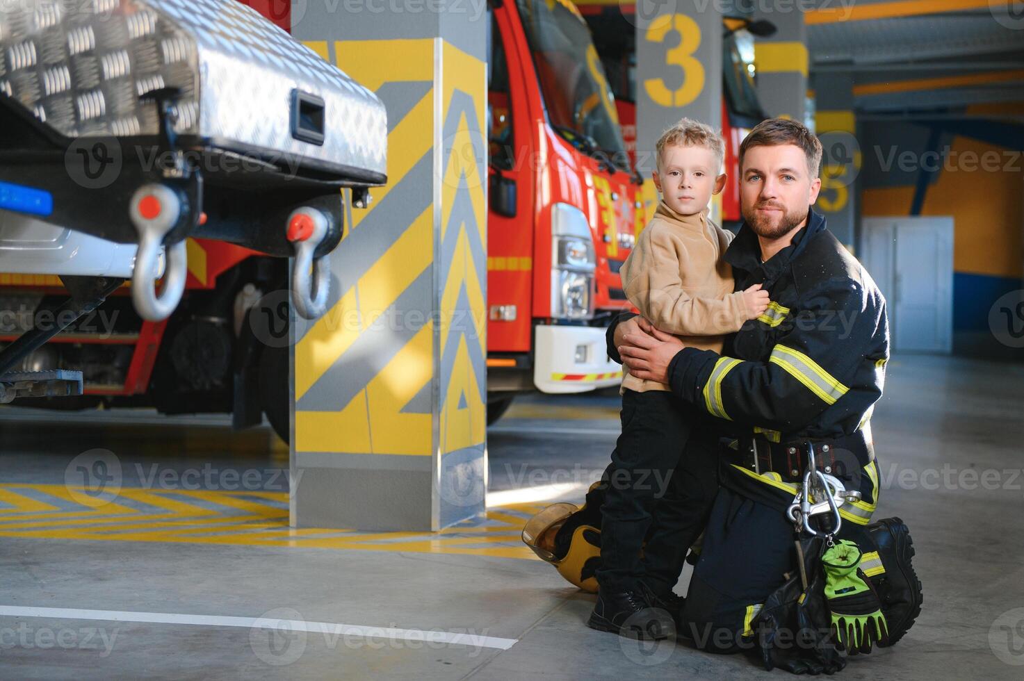 A firefighter take a little child boy to save him. Fire engine car on background photo