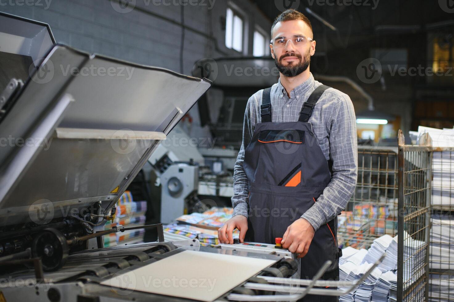 Man working in printing house with paper and paints photo