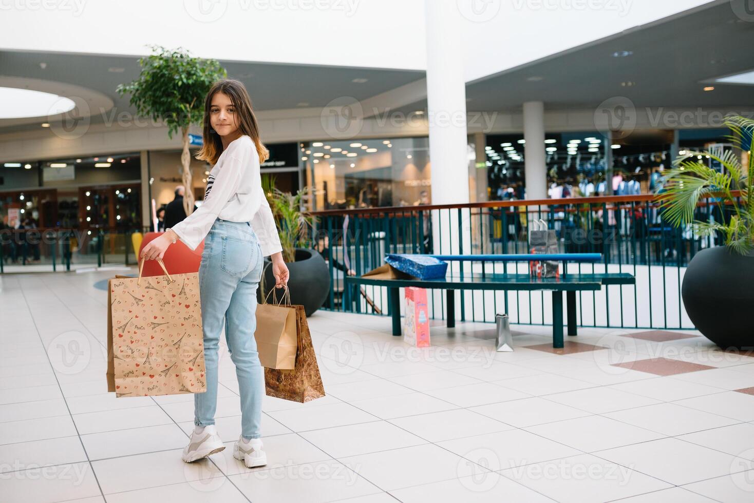 Shopping time, closeup of teenage girl legs with shopping bags at shopping mall. photo