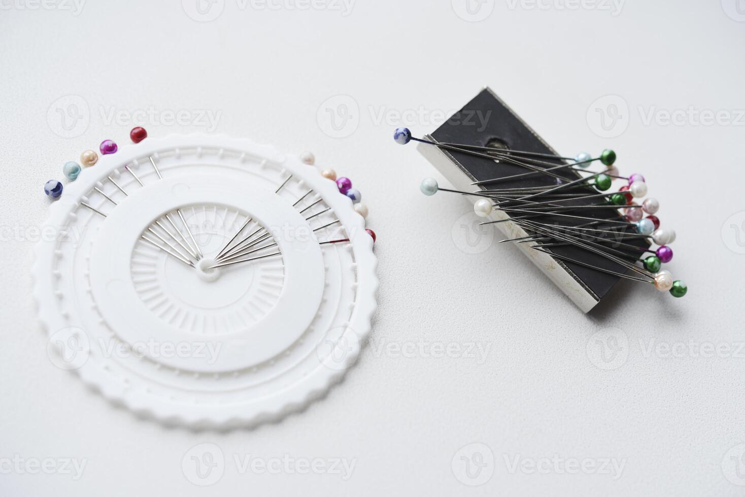 Multicolored pins on a white background. Pins and a sewing magnet. photo