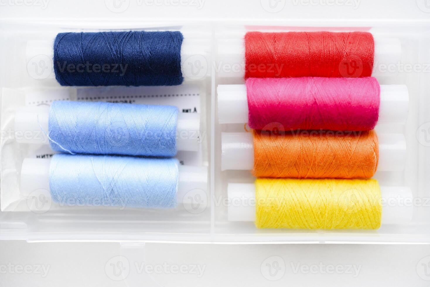 Multicolored skeins of thread in the set. The threads are in a plastic box. photo