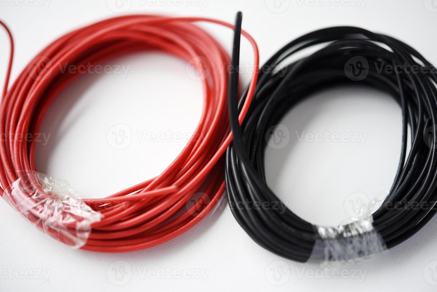 alambres para electrónica en un blanco antecedentes. dos bobinas de rojo y negro alambres foto