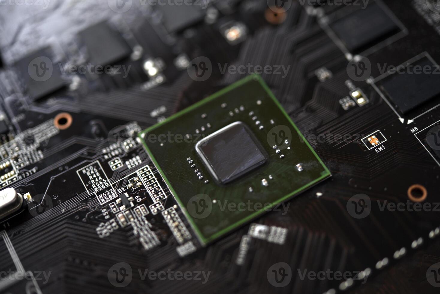 A brown printed circuit board with a processor chip and memory strips. Electronic components on the graphics card. photo