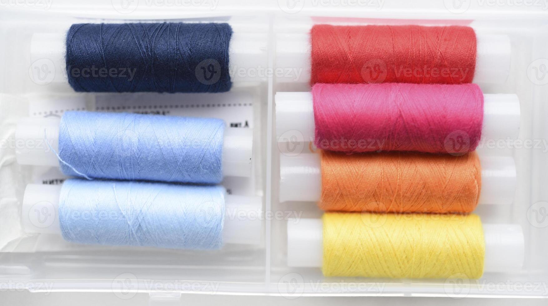 Multicolored skeins of thread in the set. The threads are in a plastic box. photo