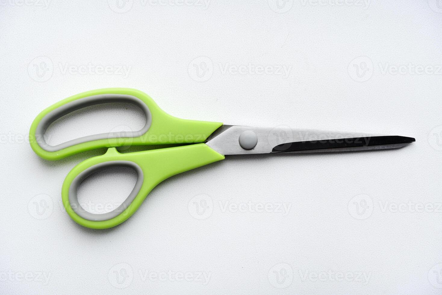 Sewing scissors on a white background. Green scissors. photo