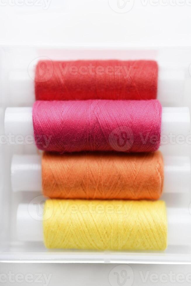 Multicolored skeins of thread in the set. The threads are in a plastic box. photo
