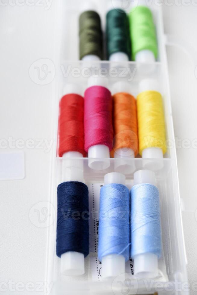 Multicolored skeins of thread in the set. The threads are in a plastic box. photo