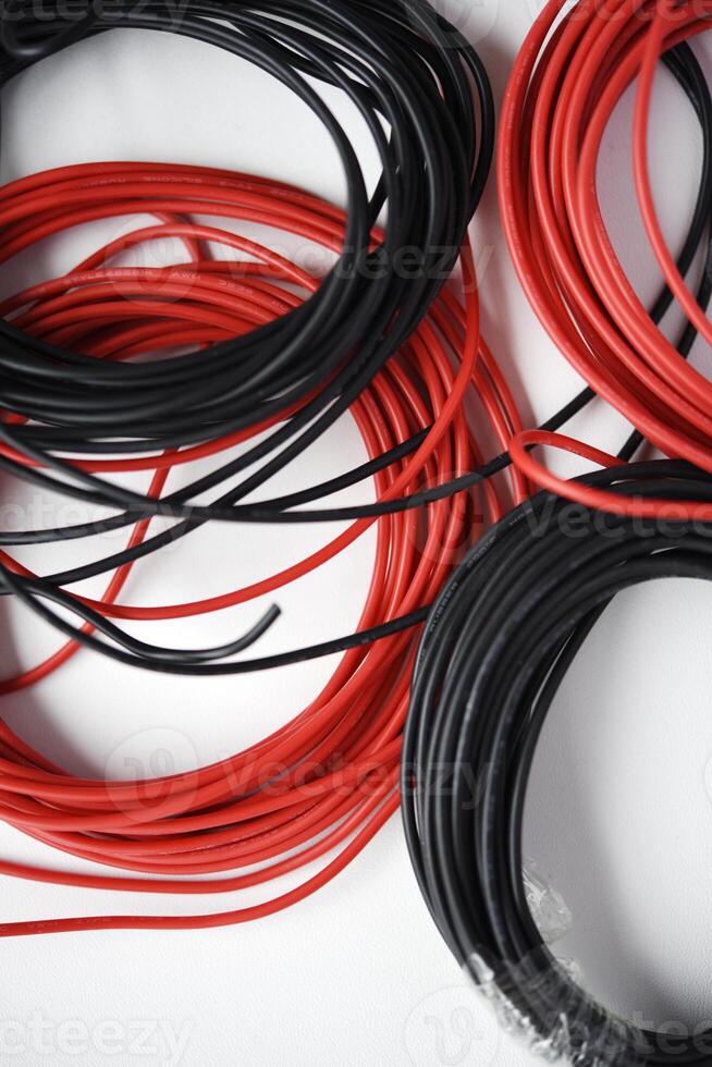 alambres para electrónica en un blanco antecedentes. dos bobinas de rojo y negro alambres foto