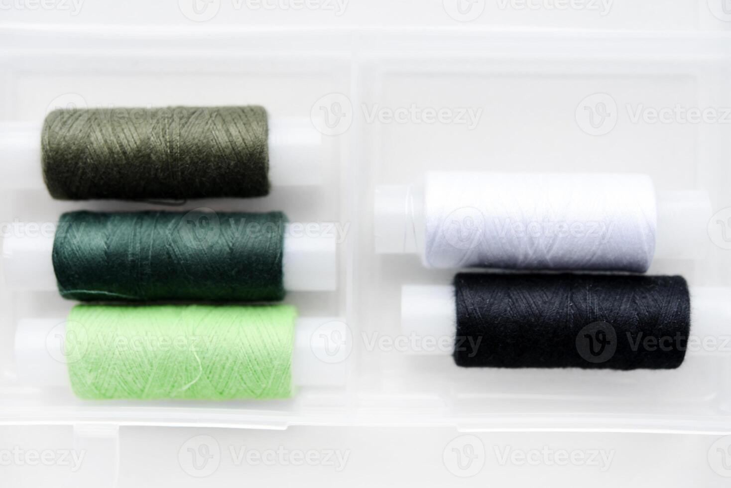 Multicolored skeins of thread in the set. The threads are in a plastic box. photo
