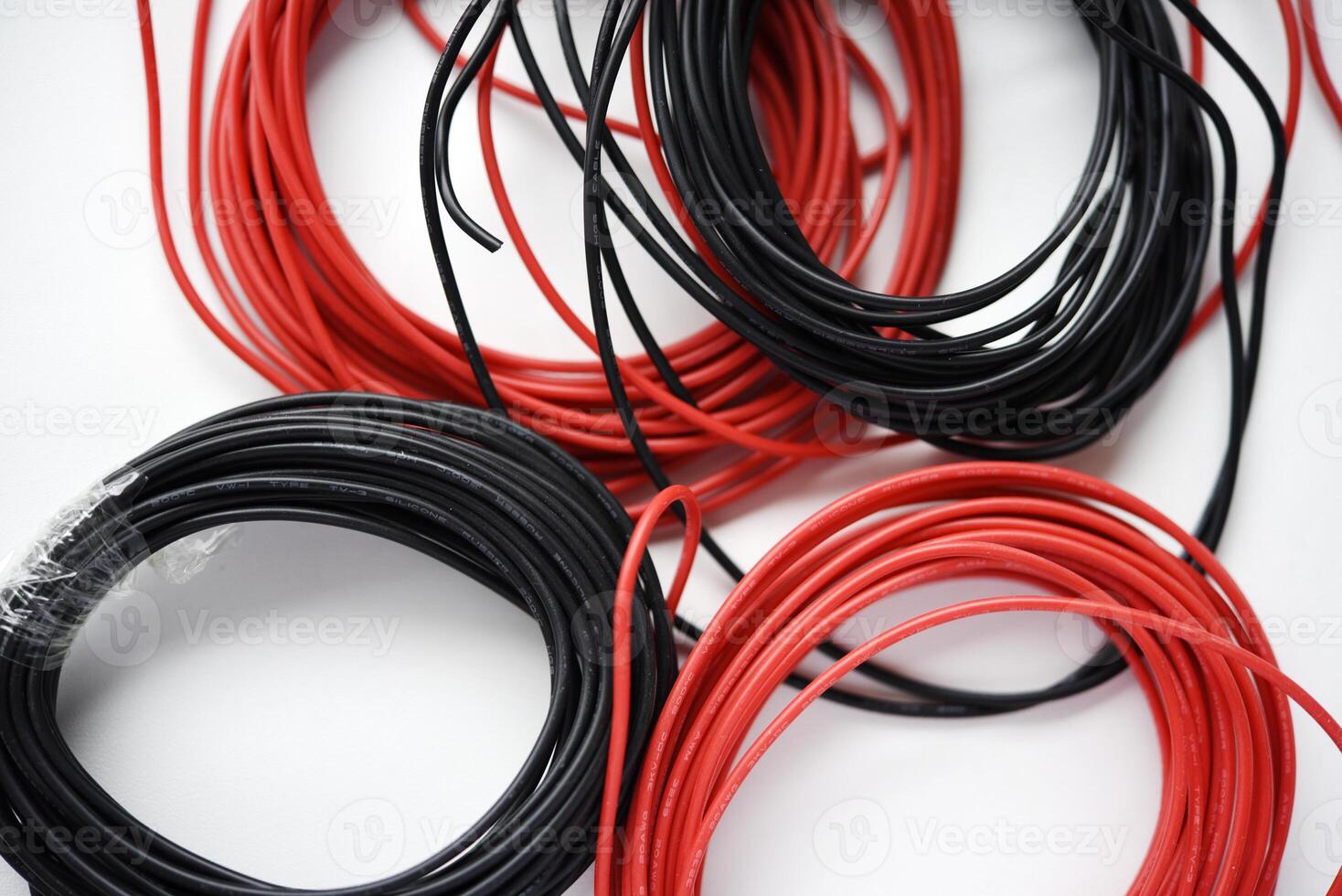 Wires for electronics on a white background. Two coils of red and black wires. photo