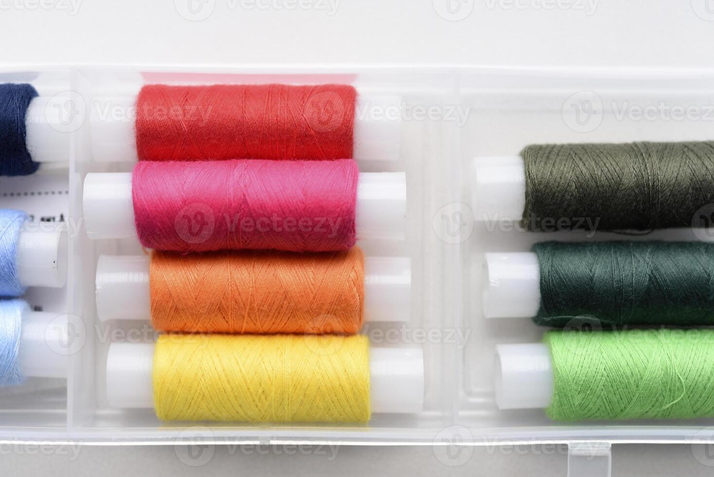 Multicolored skeins of thread in the set. The threads are in a plastic box. photo