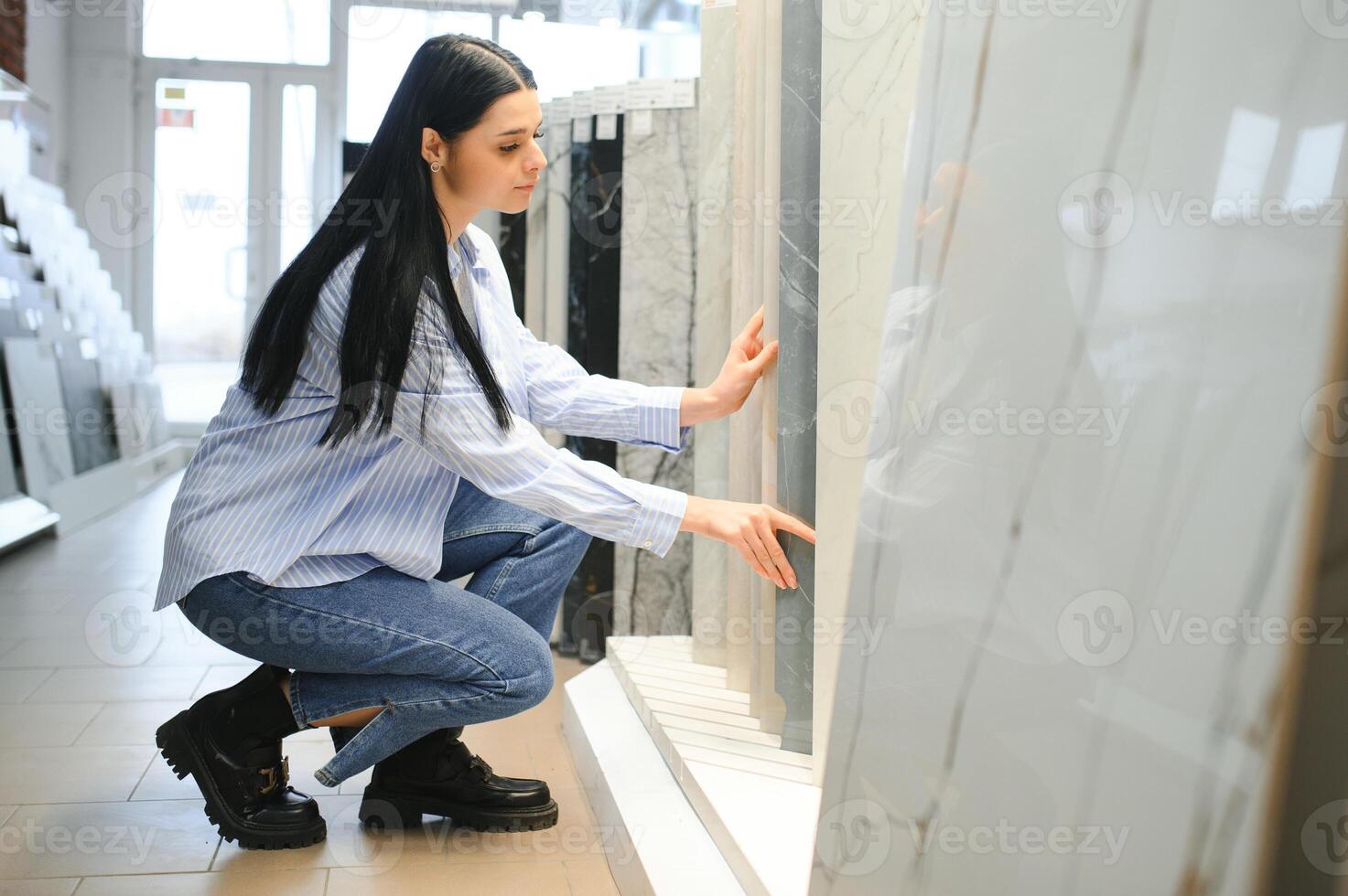 Woman choosing bathroom tile in building market photo