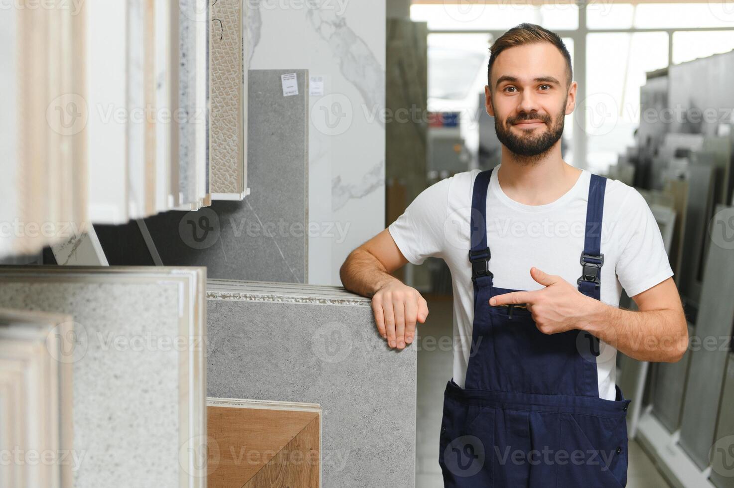 Plumber in uniform at showcase in plumbering store photo