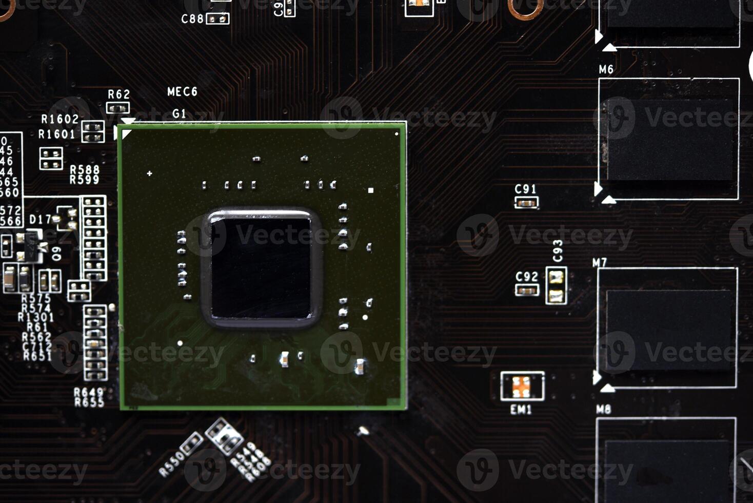 A brown printed circuit board with a processor chip and memory strips. Electronic components on the graphics card. photo