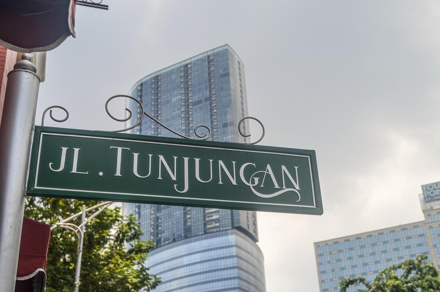 Tunjungan street nameplate with urban background photo