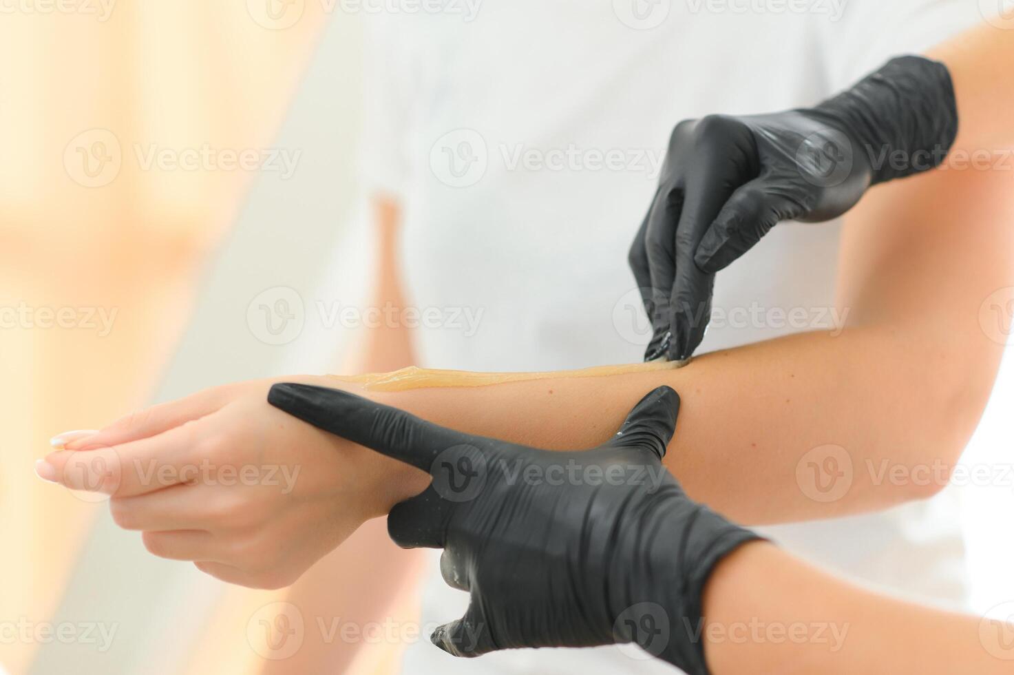 Sugar paste hair removal procedure - shugaring. Cosmetologist applies sugar paste to the hand photo