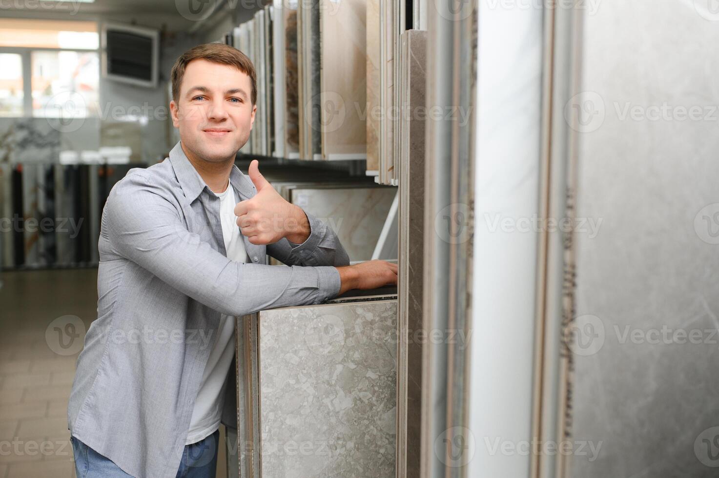 Male architect or interior designer choosing ceramic texture sample from swatch board in design studio photo