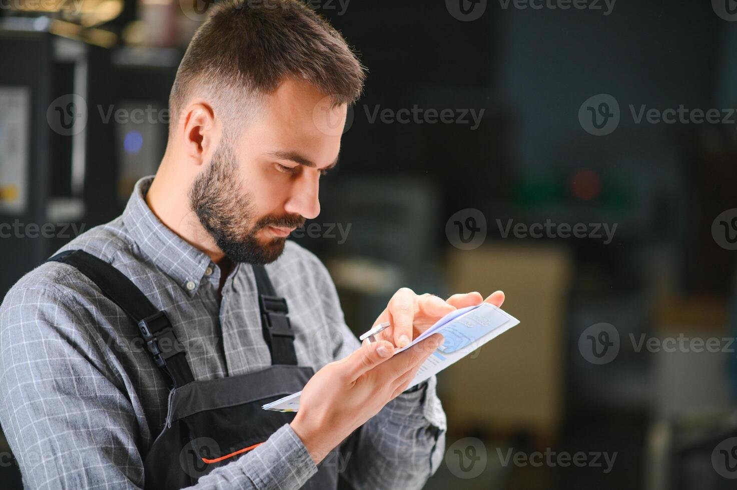 Man working in printing house with paper and paints photo