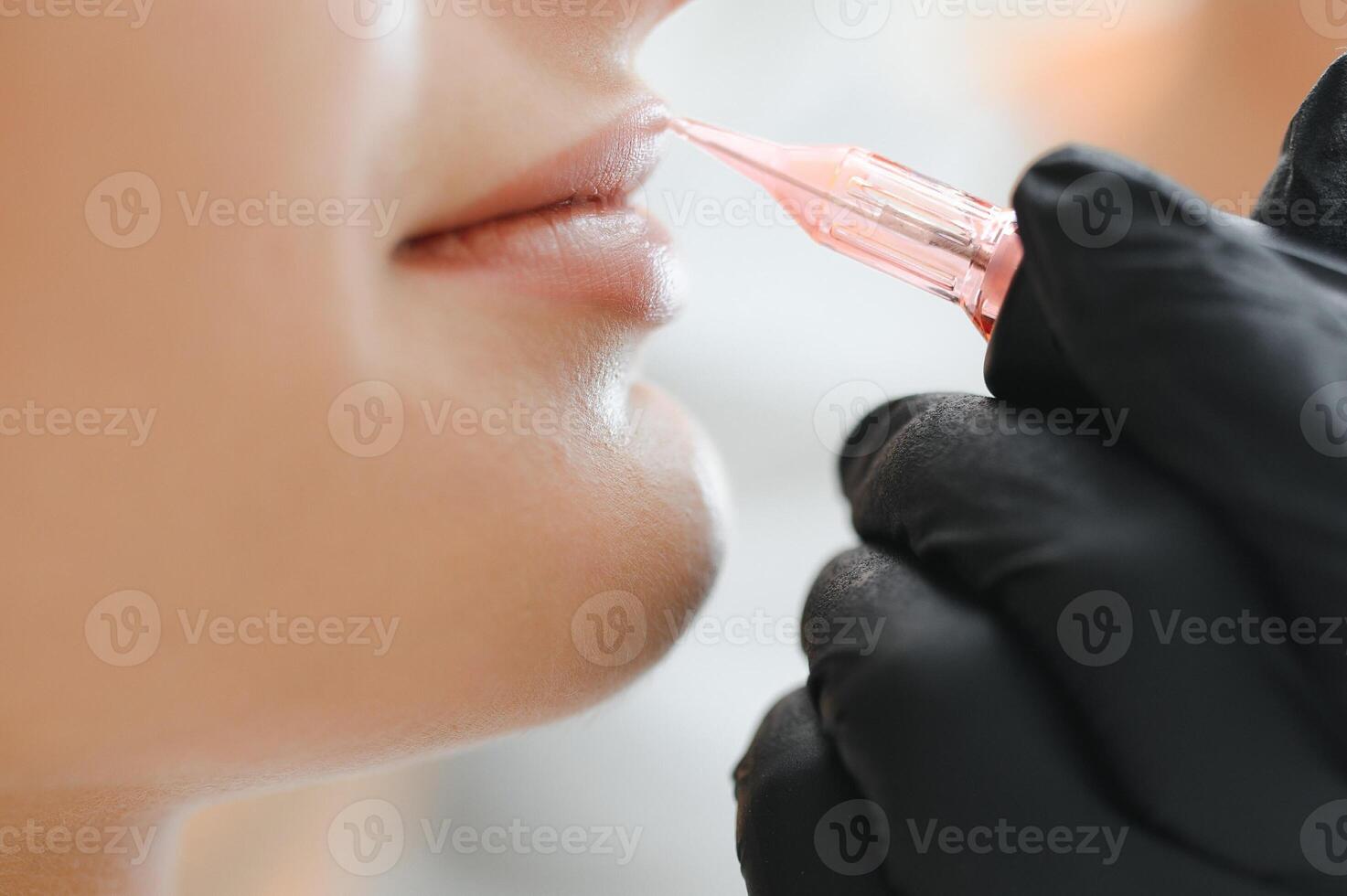 joven mujer teniendo permanente maquillaje en labios en cosmetólogo salón foto