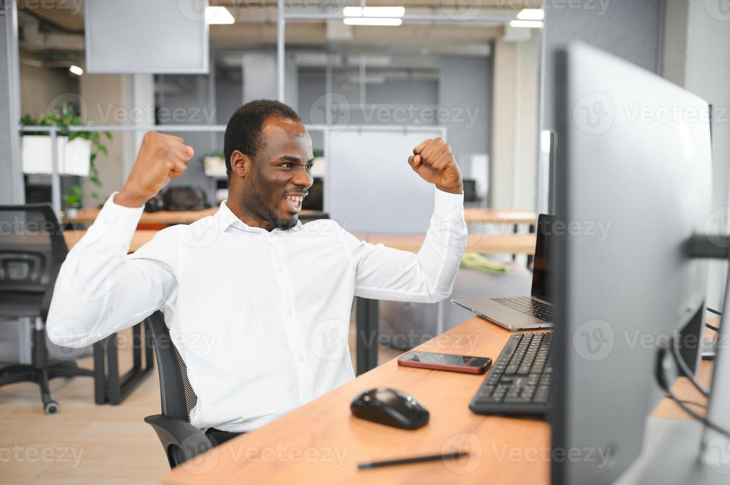 African American trader works at computer with displayed real-time stocks photo