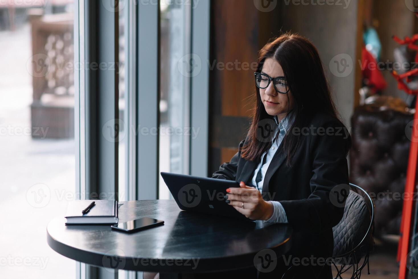 contento joven mujer de negocios utilizando tableta computadora en un cafetería. selectivo atención foto