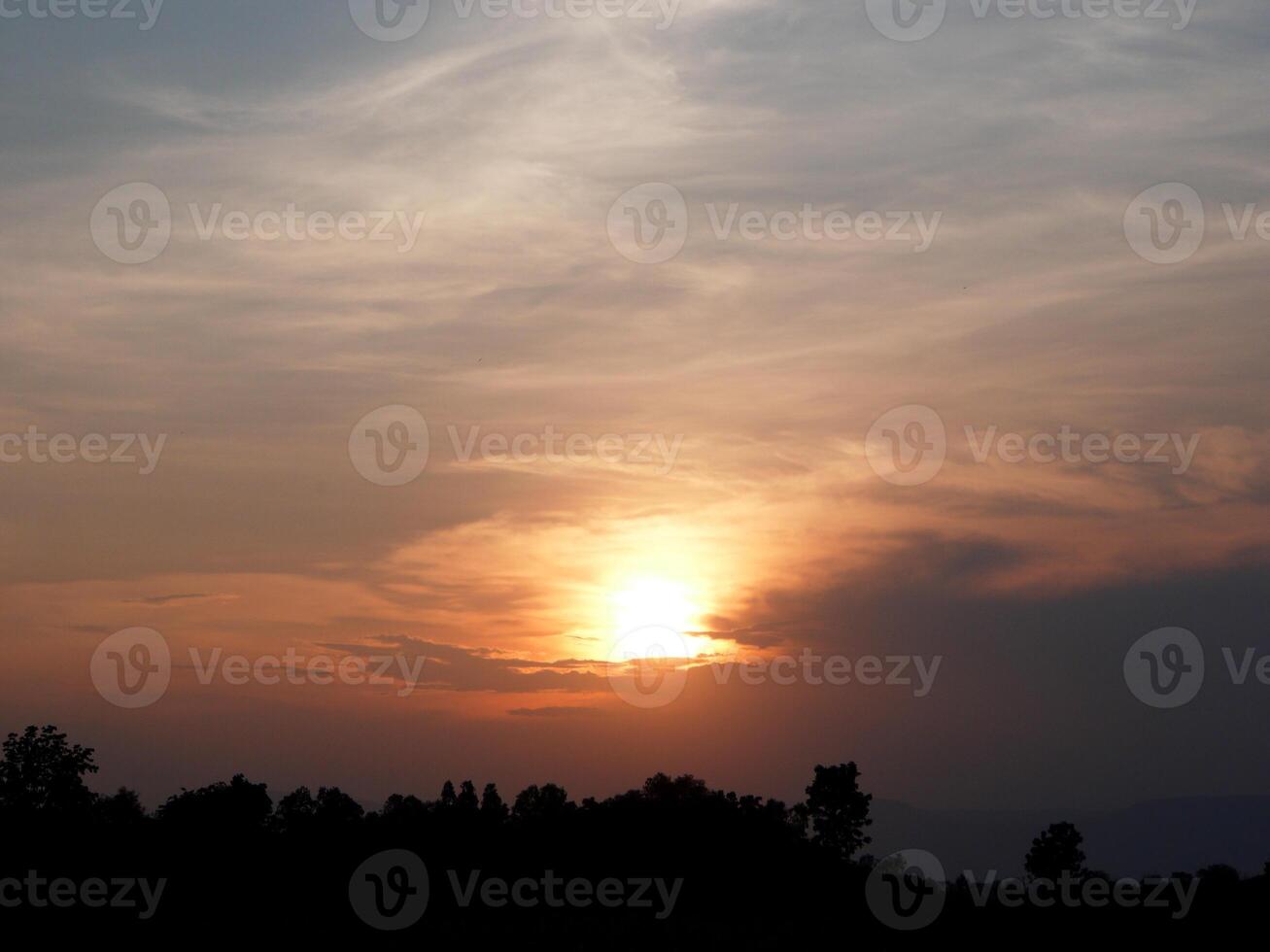 Spectacular sunset over, orange sun rising up over the horizon photo