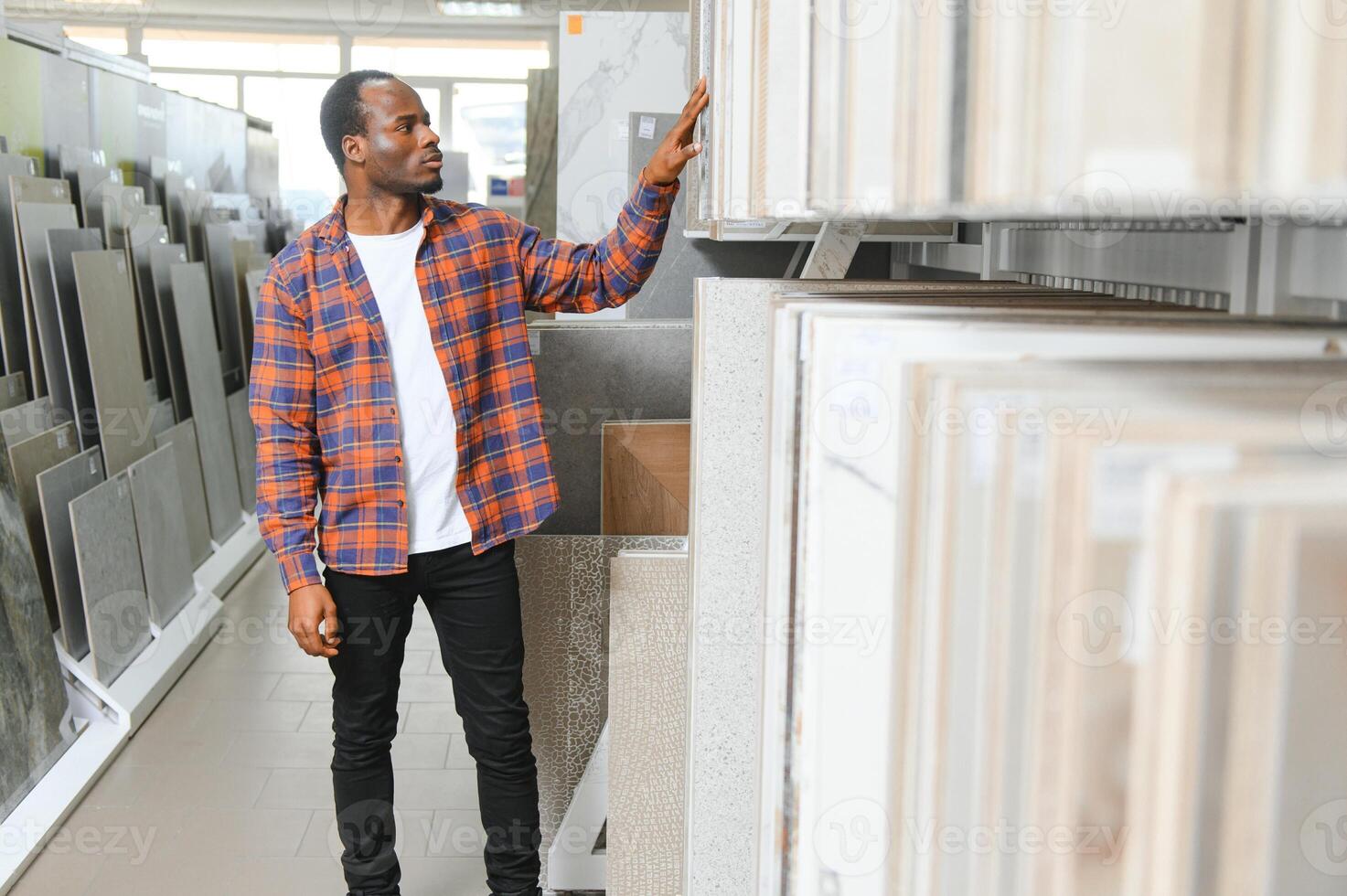 African american man customer choosing ceramic tile at building materials store photo